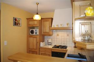 a kitchen with wooden cabinets and a stove top oven at Gite Belcastel -Village d’Exception in Belcastel