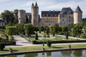 a castle with a pond in front of it at Gite Belcastel -Village d’Exception in Belcastel