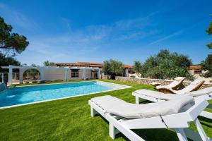 a yard with a swimming pool with chairs and a house at Casa sul lago private heated pool in Dorgali