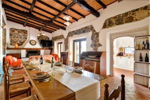 a kitchen and living room with a large wooden table at Casa sul lago private heated pool in Dorgali