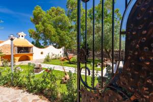 a gate in a garden with a building in the background at Casa sul lago private heated pool in Dorgali