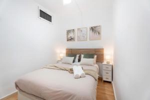 two beds in a bedroom with white walls and wood floors at Olas del Atlántico in Tacoronte