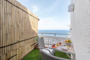a balcony with a table with food and the ocean at Olas del Atlántico in Tacoronte