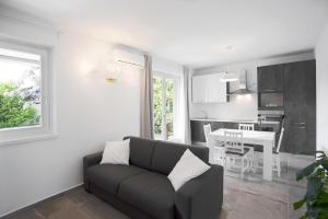 a living room with a couch and a kitchen at Appartamenti Dama 2 in Bardolino