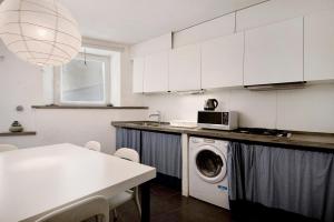 a kitchen with a washing machine and a table at Beroni su due livelli in Bonassola