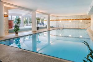 a swimming pool with blue water in a building at Fewo Jutta in Uhldingen-Mühlhofen
