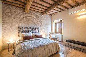 a bedroom with a bed in a room with a stone wall at Brotes Appartamento Castagno in Sovicille