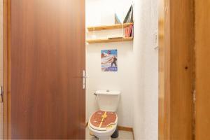 a bathroom with a toilet with a wooden door at T2 Bis - centre Barèges - cure in Barèges