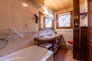 a bathroom with a tub and a sink and a toilet at Chalet Les Menuires Val Thorens in Praranger