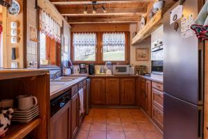 a large kitchen with wooden cabinets and a refrigerator at Chalet Les Menuires Val Thorens in Praranger