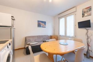 a living room with a table and a couch at T2 Bis - centre Barèges - cure in Barèges +13 photos