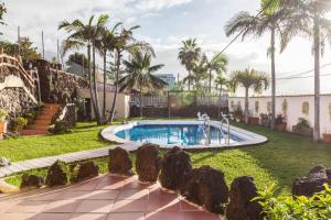 a swimming pool in a yard with palm trees at Casa Victor - Apartment 3 in La Orotava