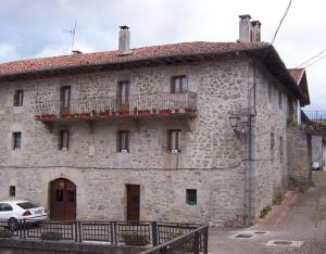an old stone building with a balcony on a street at Casa Rural Barbonea in Lekunberri