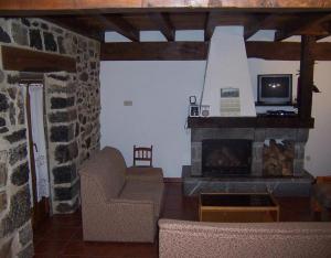 a living room with a fireplace and a tv at Casa Rural Barbonea in Lekunberri +7 photos