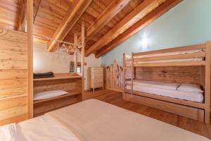 two bunk beds in a room with wooden ceilings at Civico 7 in Marmora