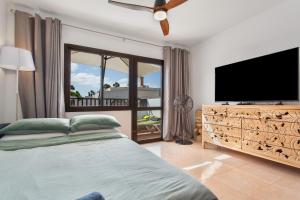 a bedroom with a bed and a flat screen tv at Casa de la Calma in Corralejo