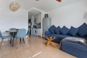 a living room with a blue couch and a table at Casa de la Calma in Corralejo