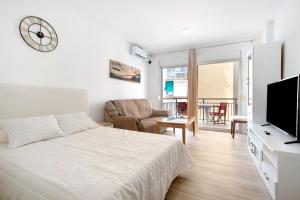 a bedroom with a bed and a tv and a living room at Apartamento Los Manantiales in Torremolinos