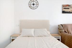 a bedroom with a bed and a clock on the wall at Apartamento Los Manantiales in Torremolinos