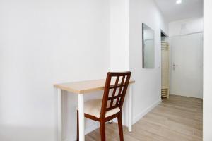 a wooden table with a chair next to a room at Apartamento Los Manantiales in Torremolinos