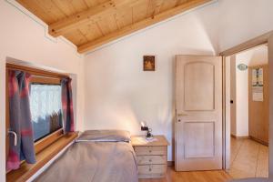 a bedroom with a bed and a window and a door at Appartamento Jolly in Livigno