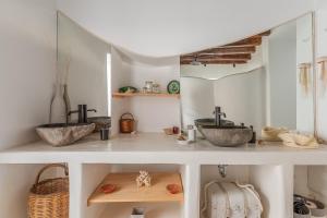 two sinks in a bathroom with two mirrors at Lithos in Kóstos +15 photos