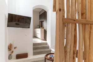 a room with a staircase with a tv on the wall at Lithos in Kóstos