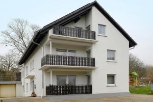 a white house with a black balcony at Haus am Buck in Müllheim