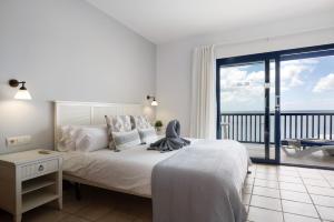 a bedroom with a bed with a view of the ocean at Malvasia 22 in Puerto Calero +21 photos