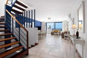 a living room with a staircase and a dining room at Malvasia 22 in Puerto Calero