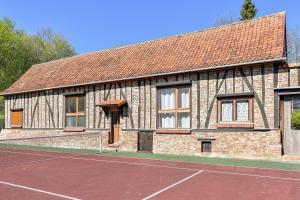 a building with a tennis court in front of it at Domaine De L'olympe in Domart-en-Ponthieu