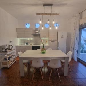 a kitchen with a white table and chairs and a kitchen with blue lights at Fortezza Villa Azzurra in Agnone Bagni