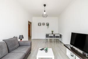 a living room with a couch and a flat screen tv at Sleeptubal Moderne Accommodatie in Alhos Vedros