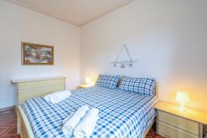 a bedroom with a blue and white bed with towels on it at Fortezza Villa Azzurra in Agnone Bagni