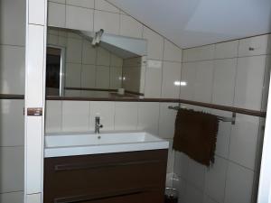 a bathroom with a sink and a mirror at Les Orchidées - chambres d'hôtes in Surtainville +16 photos