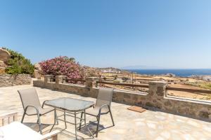 a patio with a table and chairs and the ocean at Anastasias Studios Mykonos in Plintri