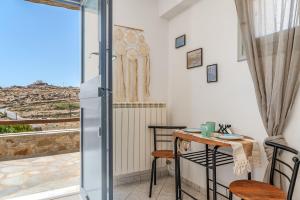 a room with a table and chairs and a balcony at Anastasias Studios Mykonos in Plintri +23 photos