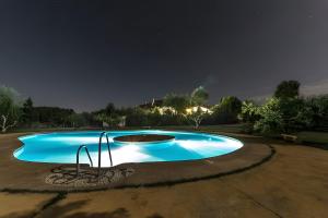 a large blue swimming pool at night at Los Jazmines in Benalúa de Guadix