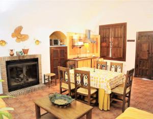 a kitchen and dining room with a table and a fireplace at Los Jazmines in Benalúa de Guadix