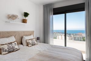 a bedroom with a large bed and a large window at Penthouse Apt With Ocean View in Estepona