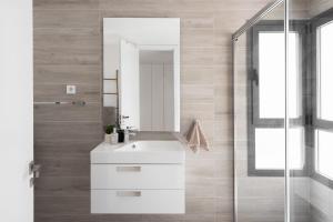 a bathroom with a white sink and a mirror at Penthouse Apt With Ocean View in Estepona +11 photos