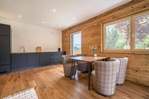 a kitchen and dining room with a table and chairs at Naturapartments Alpreid Altholz in San Pancrazio dʼUltimo