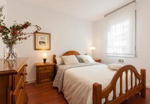 a bedroom with a bed and a desk and a window at Canet Platja Apartment in Canet de Mar +12 photos