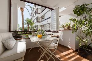 an apartment balcony with a table and a couch at Canet Platja Apartment in Canet de Mar
