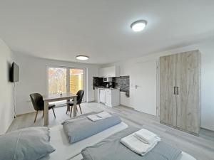 a bedroom with a bed and a desk and a kitchen at Ferienwohnung Hochwangen in Ichenhausen