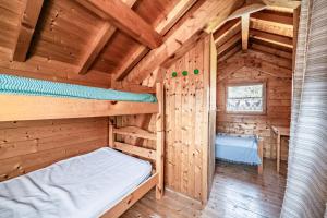 a bedroom with a bed in a wooden cabin at Chalet 4p Simple - La Gélinotte in Verchaix