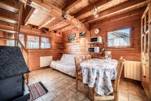 a dining room with a table and a bed in a cabin at Chalet 4p Simple - La Gélinotte in Verchaix