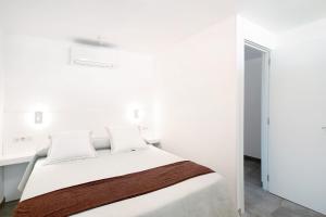 a white bedroom with a bed with white walls at Tamaran Bureba 511 in Maspalomas +12 photos