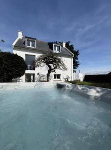 a house with a swimming pool in front of a house at Lividig Bleue en face de la mer in Brignogan-Plage