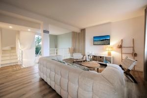 a living room with a large couch and a table at Lividig Bleue en face de la mer in Brignogan-Plage